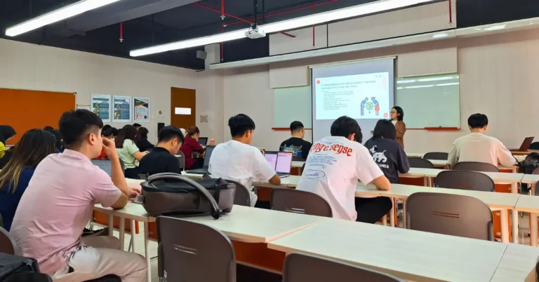 Speaker from Synergy delivering a presentation on work ethic during a guest lecture at Universitas Ciputra
