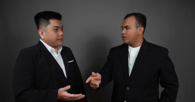 Dua pebisnis sedang berdiskusi mengenai persyaratan dan proses Pengusaha Kena Pajak (PKP) di ruang pertemuan